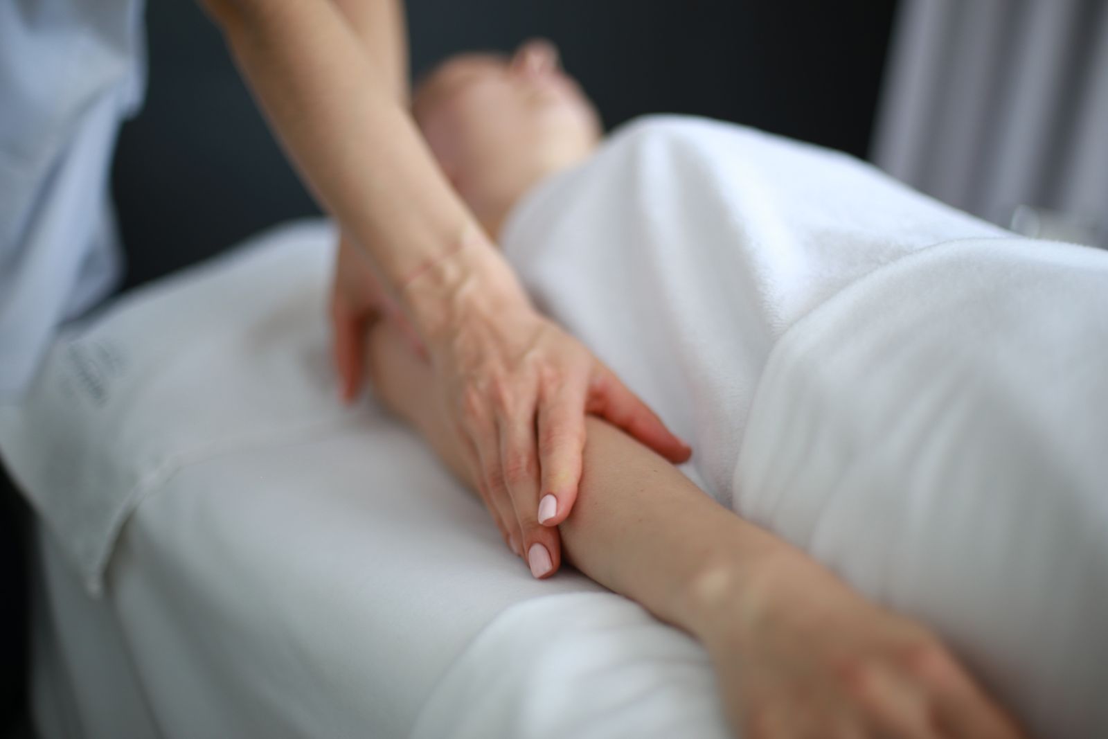 Sanfte Handgriffe am Arm während einer Microkinesitherapie-Sitzung